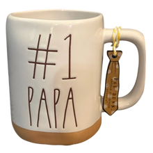 Load image into Gallery viewer, Mug with '#1 Papa' text, tan bottom and a tie-shaped tag on a white background
