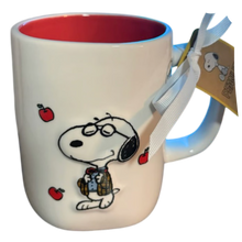 Load image into Gallery viewer, White mug with red inside that shows a Snoopy charcter dress in a teachers outfit and blazer with apples floating around it.
