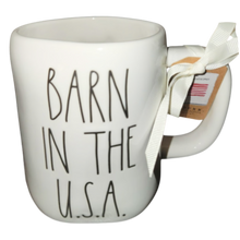 Load image into Gallery viewer, White mug with 'Barn in the U.S.A.' text and a tag on a white background
