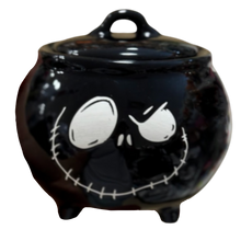 Load image into Gallery viewer, A glossy black ceramic cauldron-shaped lidded pot with a white Jack Skellington face design, isolated on a white background.
