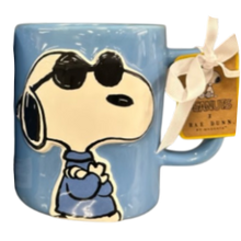Load image into Gallery viewer, Blue mug with Snoopy cartoon character wearing sunglasses and a bow tie, featuring a 'Peanuts' label.

