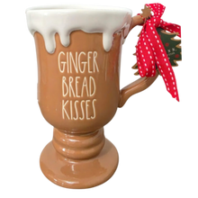 Load image into Gallery viewer, A gingerbread-themed ceramic mug with 'GINGER BREAD KISSES' written on the front, featuring white icing-like detailing at the rim, a brown handle, and a red polka-dot ribbon bow with a small hanging tag.
