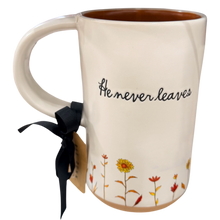 Load image into Gallery viewer, An off-white ceramic mug with a brown interior, featuring the black cursive text 'He never leaves' and a floral design at the bottom. It is tied with a black ribbon and a paper tag, shown on a plain white background.
