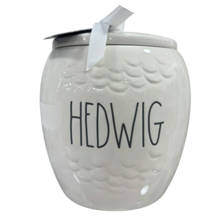 Load image into Gallery viewer, A white ceramic canister with a lid, featuring the name 'HEDWIG' in black hand-lettered text on the front and a white ribbon tied to the lid, shown against a plain white background.
