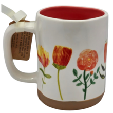 Load image into Gallery viewer, White mug with floral design and red interior and tan bottom, featuring a tag on handle.
