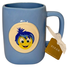 Load image into Gallery viewer, Blue mug with white round image of the character Joy from the Disney movie Inside Out.
