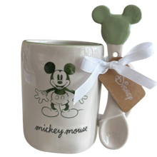 Load image into Gallery viewer, A white ceramic mug with a green Mickey Mouse graphic and the words 'mickey mouse' printed below, shown with a matching white spoon featuring a green Mickey Mouse head handle and tied with a white ribbon and Disney tag.
