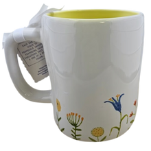 Load image into Gallery viewer, White mug with floral designs and a yellow interior, on a white background
