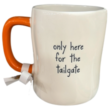 Load image into Gallery viewer, An off-white ceramic mug with a bright orange handle and a white ribbon tag, featuring the black printed text 'only here for the tailgate'.
