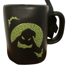 Load image into Gallery viewer, A black ceramic mug featuring a lime green graphic of a spooky ghostly face known as Oogie Boogie with a bat silhouette, shown against a plain white background.
