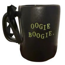 Load image into Gallery viewer, A black ceramic mug with a black ribbon handle bow and the words 'OOGIE BOOGIE.' printed in a light green typewriter font on the side, isolated on a white background.
