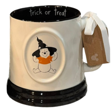 Load image into Gallery viewer, A ceramic mug featuring Winnie the Pooh wearing a witch hat and orange outfit, with 'trick or treat' written inside the black rim. The mug has a white handle with a white ribbon and a brown paper tag.
