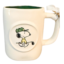 Load image into Gallery viewer, White mug with a Snoopy cartoon character design holding a golf club on a white background with green interiror.
