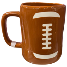 Load image into Gallery viewer, A brown ceramic mug designed to look like a football, featuring a white laces football pattern on the front, isolated on a white background.
